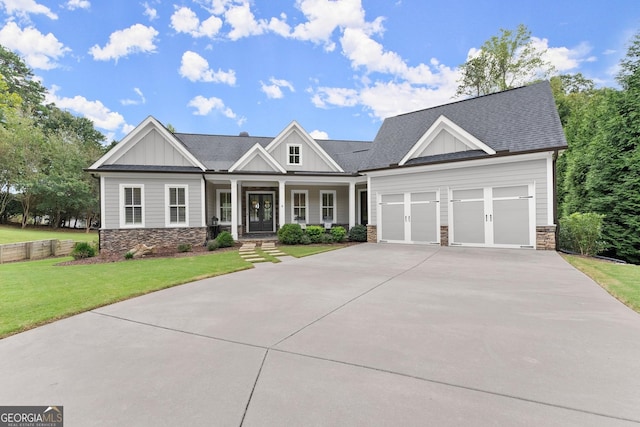 craftsman inspired home featuring a front yard, a garage, and covered porch