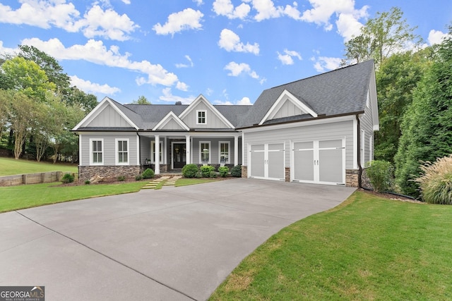 craftsman inspired home featuring a porch, a garage, and a front lawn