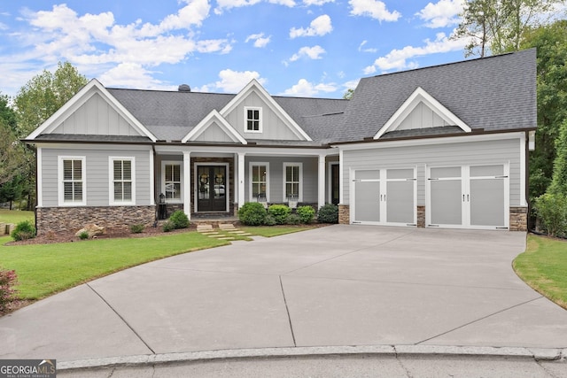 craftsman-style home featuring a front lawn, covered porch, and a garage