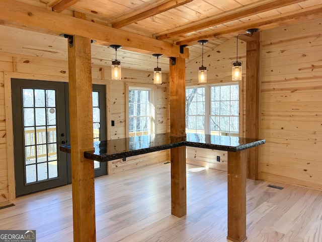 playroom featuring wooden ceiling, light hardwood / wood-style flooring, beamed ceiling, plenty of natural light, and wooden walls