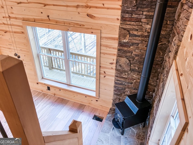 details with wood-type flooring, a wood stove, and wooden walls