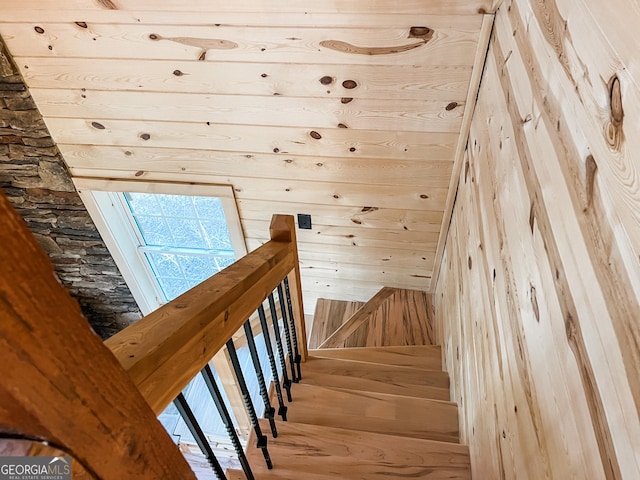 stairs with wood walls and hardwood / wood-style floors