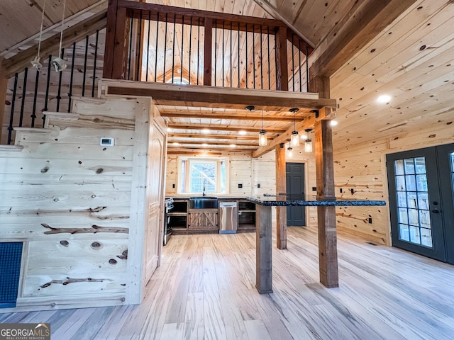 interior space with wood walls, wood-type flooring, high vaulted ceiling, and wooden ceiling