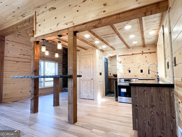 interior space featuring light hardwood / wood-style floors, wood ceiling, sink, stainless steel stove, and wood walls