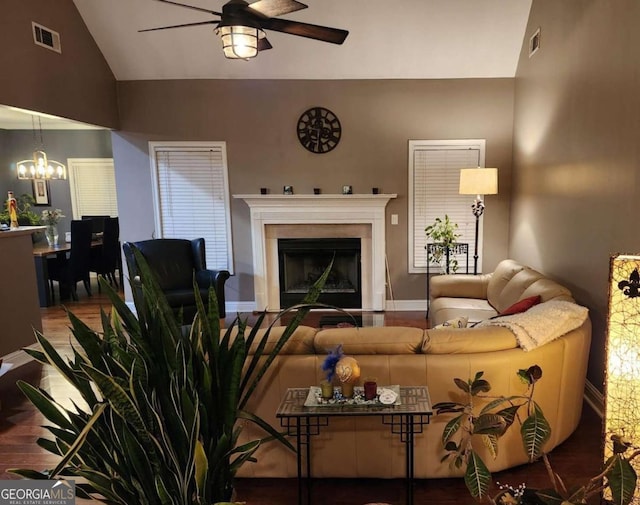 living room with hardwood / wood-style floors, ceiling fan with notable chandelier, and lofted ceiling