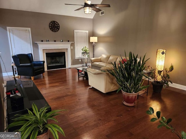 living room with dark hardwood / wood-style floors, ceiling fan, and vaulted ceiling