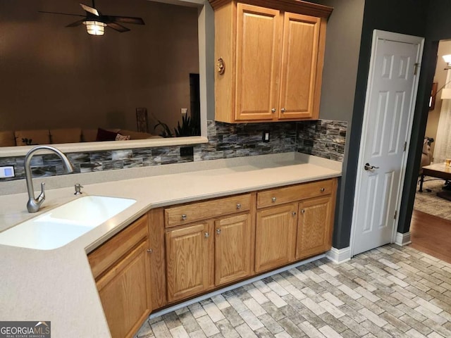 kitchen with ceiling fan, decorative backsplash, and sink