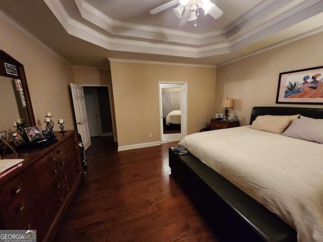 bedroom with ceiling fan, dark hardwood / wood-style flooring, a raised ceiling, and crown molding