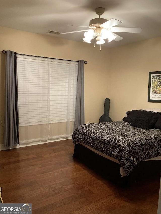 bedroom featuring ceiling fan and dark wood-type flooring