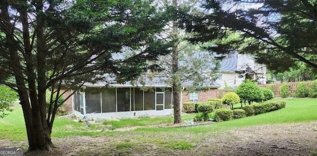 view of side of property featuring a sunroom and a yard