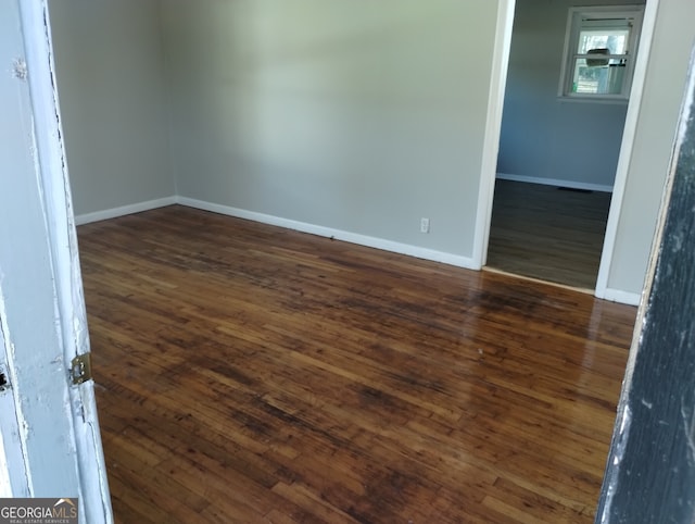 unfurnished room with dark hardwood / wood-style flooring