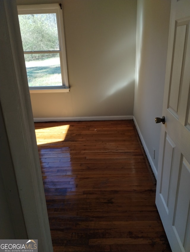 empty room with dark hardwood / wood-style flooring