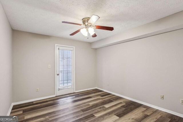 unfurnished room featuring ceiling fan, dark hardwood / wood-style flooring, and a textured ceiling