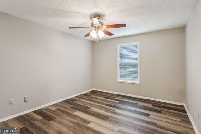 empty room with dark hardwood / wood-style flooring and a textured ceiling