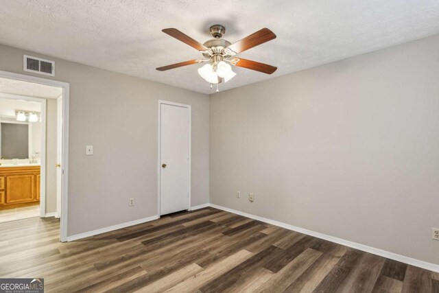 unfurnished bedroom featuring a textured ceiling, ceiling fan, and dark hardwood / wood-style floors