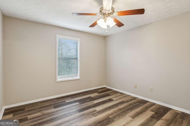 unfurnished room featuring ceiling fan, a healthy amount of sunlight, dark hardwood / wood-style flooring, and a textured ceiling