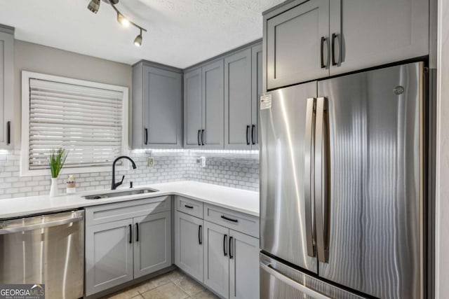 kitchen with gray cabinetry, sink, appliances with stainless steel finishes, and tasteful backsplash