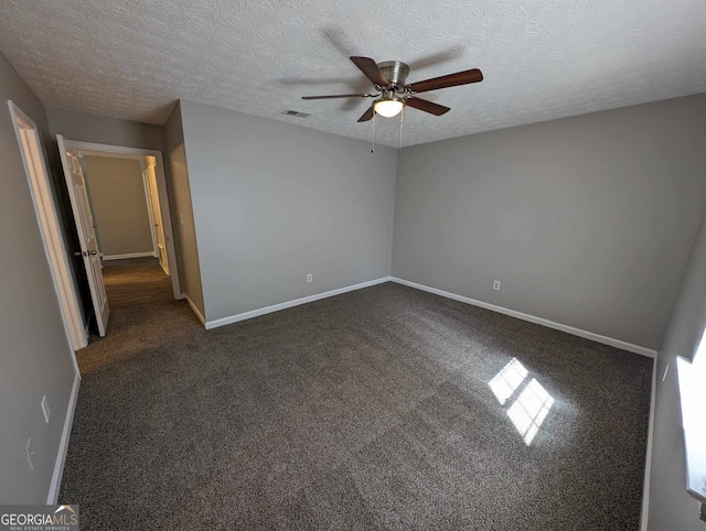 carpeted empty room featuring ceiling fan and a textured ceiling