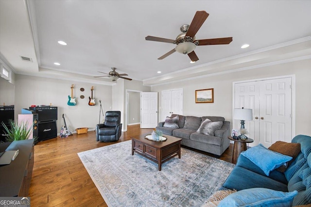 living room with hardwood / wood-style floors, ceiling fan, and crown molding