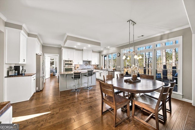 dining room featuring ornamental molding and dark wood-type flooring