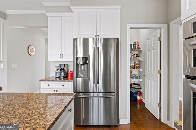 kitchen with white cabinets, dark hardwood / wood-style flooring, stainless steel appliances, and dark stone counters