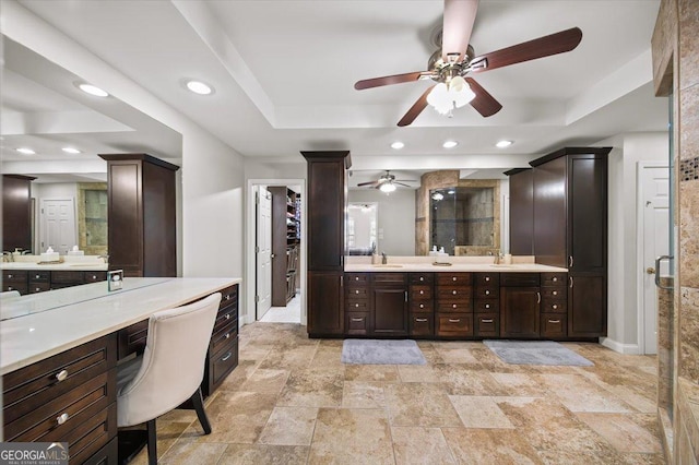 bathroom with a tray ceiling, a shower with door, and vanity