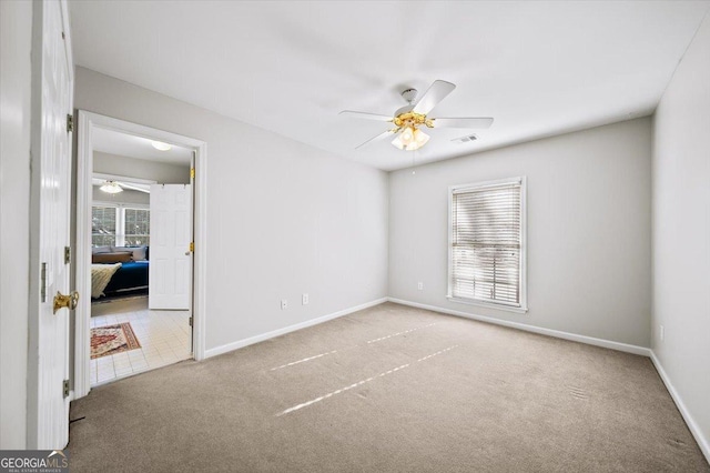 carpeted spare room with ceiling fan