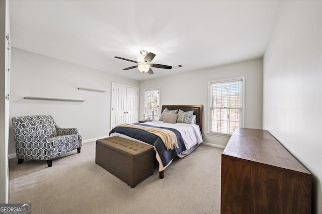 bedroom featuring multiple windows, ceiling fan, and light carpet