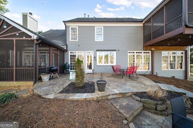 rear view of property featuring a patio and a sunroom