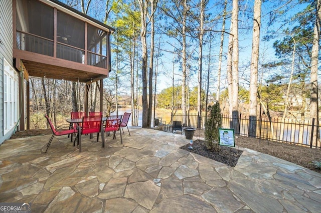 view of patio with a sunroom and a water view