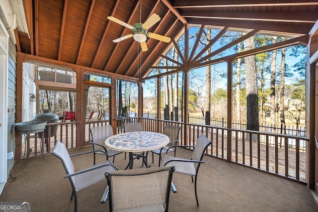 sunroom featuring a healthy amount of sunlight, ceiling fan, wood ceiling, and lofted ceiling with beams