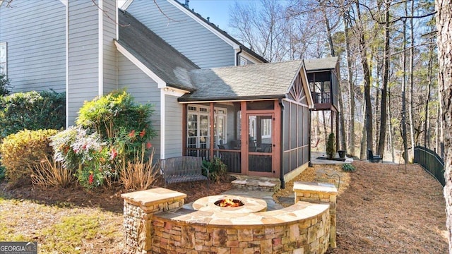 exterior space with an outdoor fire pit and a sunroom