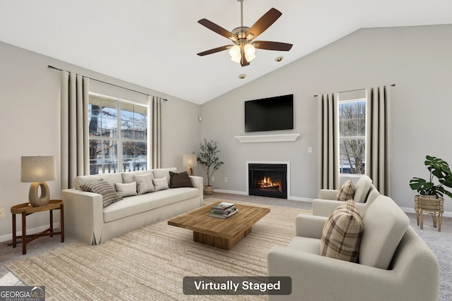 carpeted living room with vaulted ceiling, ceiling fan, and a healthy amount of sunlight