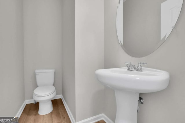 bathroom with wood-type flooring and toilet