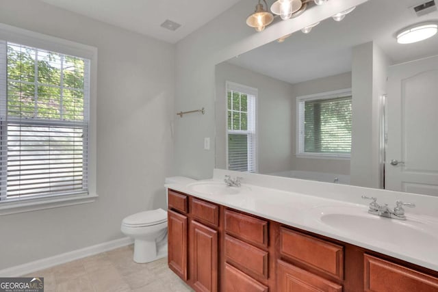 bathroom with vanity, toilet, and a bath