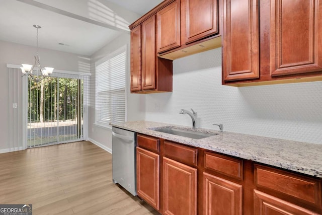 kitchen with dishwasher, an inviting chandelier, sink, decorative light fixtures, and light stone counters