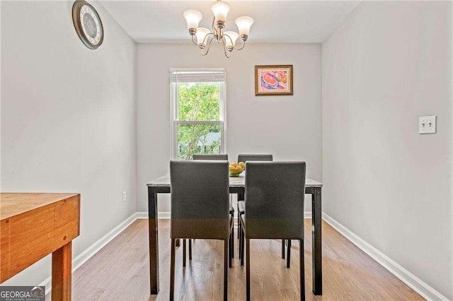 dining area featuring light wood-type flooring and an inviting chandelier