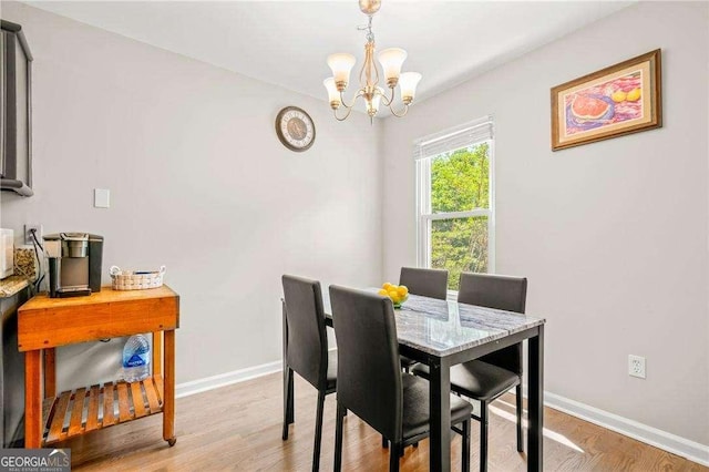 dining room with light hardwood / wood-style floors and an inviting chandelier