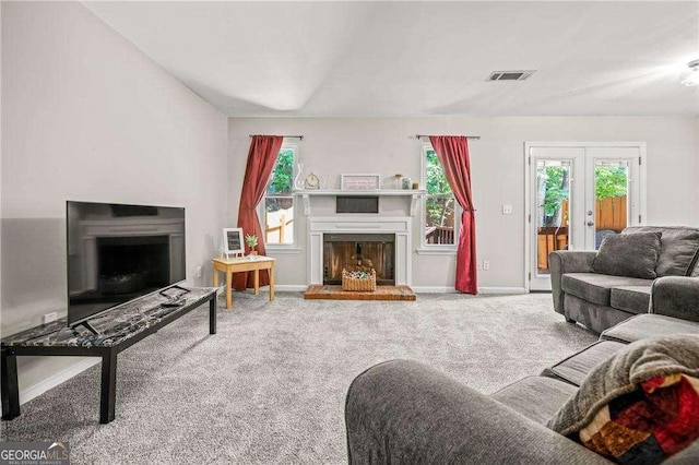 living room with french doors, carpet floors, and a healthy amount of sunlight