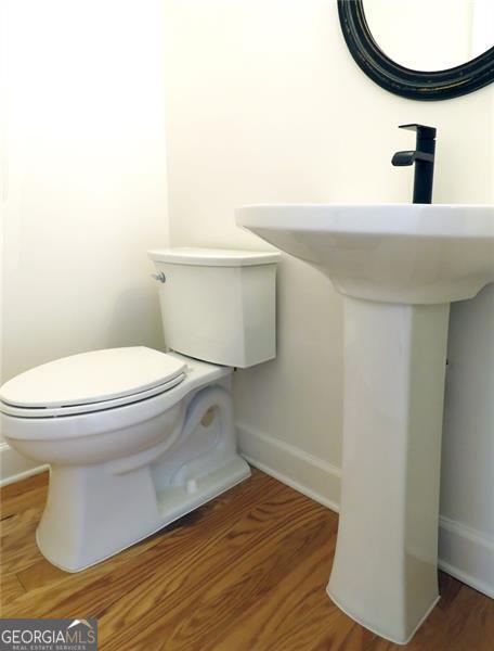 bathroom with hardwood / wood-style floors and toilet