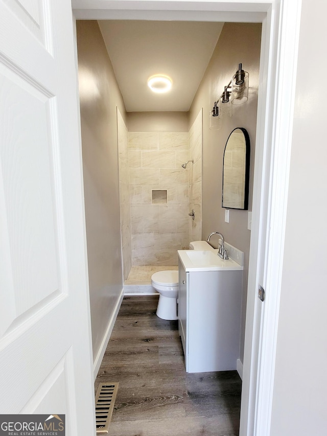 1311 Juniper St, Lagrange, GA 30240 - bathroom featuring toilet, visible vents, tiled shower, vanity, and wood finished floors