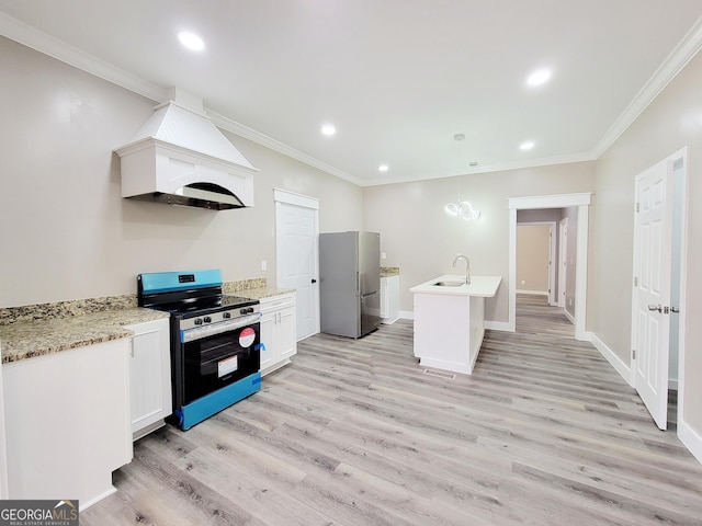 kitchen with custom exhaust hood, stove, sink, decorative light fixtures, and stainless steel refrigerator