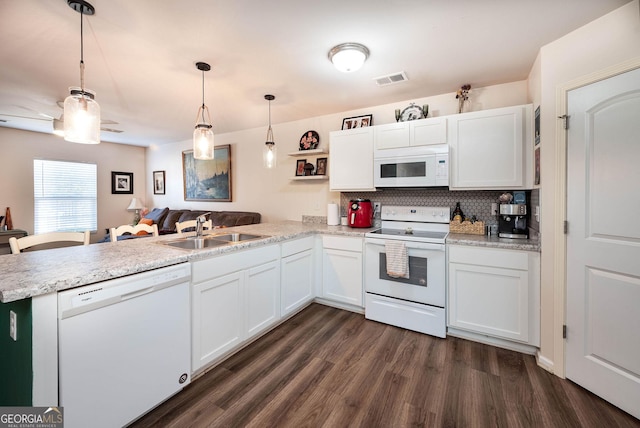 kitchen featuring white appliances, visible vents, dark wood finished floors, a peninsula, and a sink