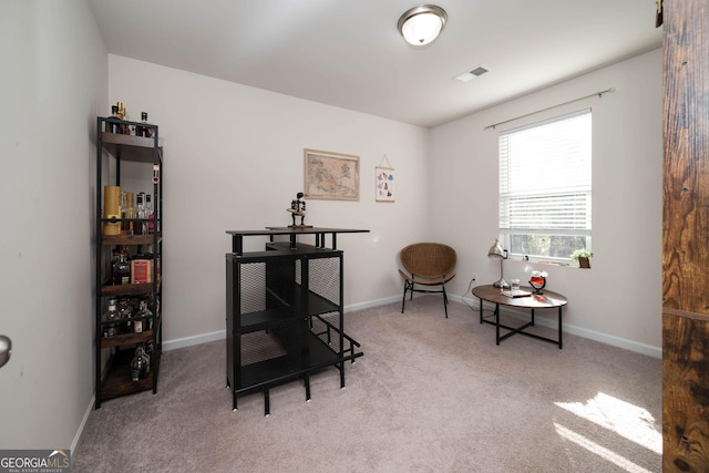 sitting room featuring light colored carpet, visible vents, and baseboards