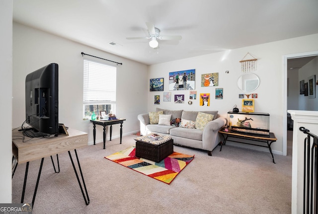 living area featuring visible vents, light colored carpet, baseboards, and a ceiling fan