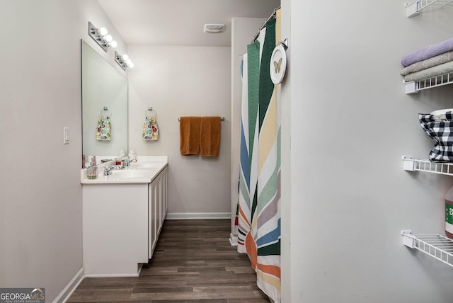 bathroom featuring vanity, wood finished floors, and baseboards