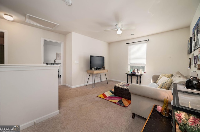 living area featuring light carpet, baseboards, attic access, and ceiling fan
