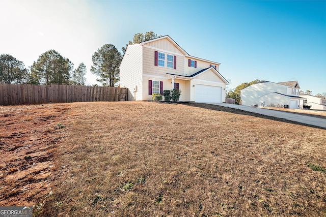 traditional-style house featuring an attached garage, driveway, and fence