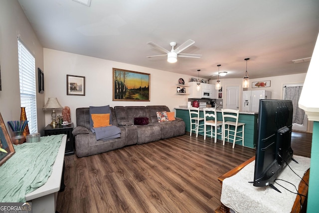 living room with ceiling fan and dark wood-type flooring