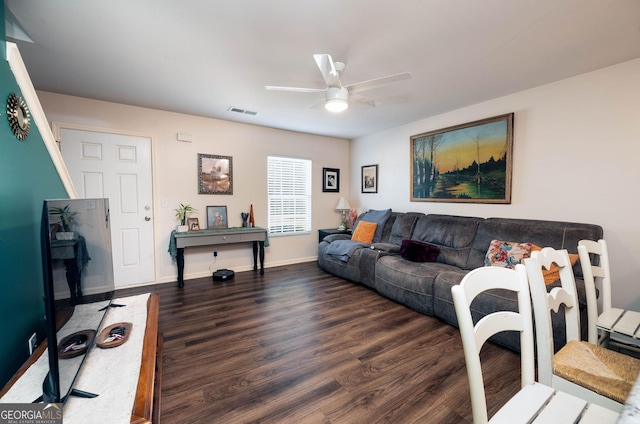 living area with visible vents, baseboards, dark wood-type flooring, and a ceiling fan